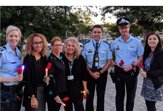 Domestic violence workers with police at candlelight vigil